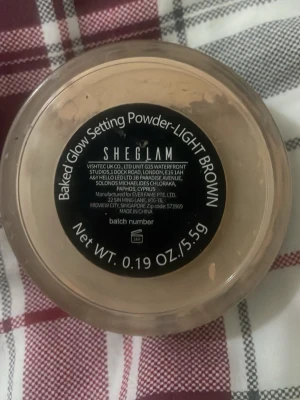 Svart puderkompakt från SHEGLAM - Snygg svart puderkompakt från SHEGLAM med rund form och stilren design. Perfekt att ha i väskan för snabba touch-ups. Kompaktens lock har tydlig SHEGLAM-logga i vitt.