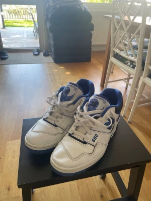 New Balance 550 - Säljer ett par New Balance 550 sneakers i vitt och blått. De är använda bara ett par enstaka gånger. Skriv om fler frågor!