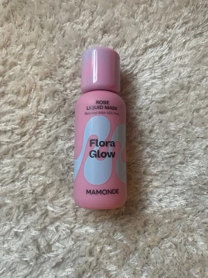 Mamonde Flora Glow Rose Liquid Mask - Mamonde Flora Glow Rose Liquid Mask är en flytande ansiktsmask/serum i en rosa plastflaska med vita och ljusblå detaljer. Masken är boostad med 10% PHA och ger huden lyster. Perfekt för dig som vill ha glow och återfuktning.  Har endast testat den på handen. 💞