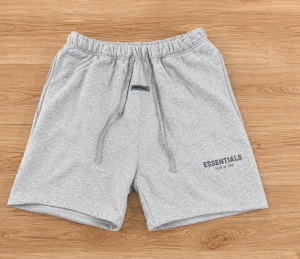 Grå Essentials sweatshorts - Snygga ljusgrå sweatshorts från Essentials med tryckt logga på vänster ben. Shortsen har elastisk midja med dragsko och två sidofickor. Perfekta för en avslappnad och sportig stil.