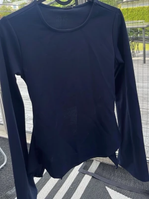 Marinblå långärmad topp med knyt - Jättefin marinblå långärmad tröja med snygg passform med knyte i ryggen. Perfekt för dig som vill ha en trendig och stilren look. Aldrig använd med prislappen kvar💗