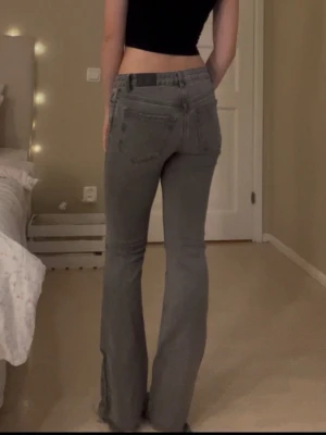 Grå bootcut jeans midwaist - Säljer ett par gråa snygga bootcut jeans i midwaist. Jeansen har utsvängda ben och snygg tvätt. Säljer då de inte passar mig längre. Trasiga längst ned i benen, syns på sista bilden💗