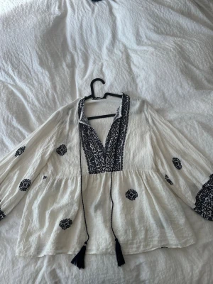 Vit,blå blus  - Säljer en vit blus med fina mörkblå detaljer. Från Zara.