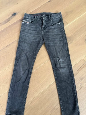 Svarta slim fit jeans från diesel  - Snygga svarta slim fit jeans med lätt slitning och klassisk femficksmodell. Jeansen har en smal passform och normal midja, perfekta till en avslappnad streetstyle-look. Materialet är troligtvis bomull med lite stretch för extra komfort. 29/30 storlek 
