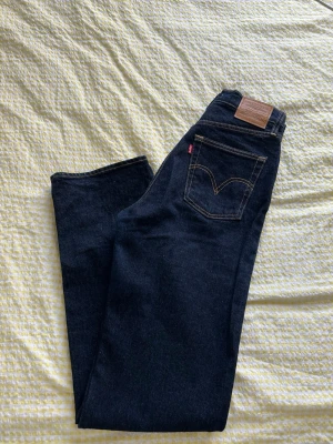 Levi’s Ribcage straight  - Snygga mörkblå jeans från Levi's med klassisk femficksdesign och kontrastsömmar. Modellen heter Ribcage straight och är i storlek w26 L34. Nypris: 1349kr