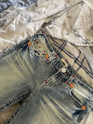 True Religion ljusblå jeans - Jätte snygga true religion jeans. Helt nya men de är uppsydda så de passar mig som är 1,60 typ. Man kan även ”dra ner de” så de blir nått antal cm längre. Jätte snygga röda sömmar. Waist 30