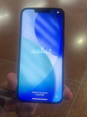 Svart iPhone med dubbla kameror - Säljer en svart iPhone med stilren design och rundade hörn. Telefonen har två bakre kameror placerade i hörnet och en stor skärm med tunn ram. Baksidan är i glas och har den klassiska Apple-loggan. Perfekt för dig som vill ha en modern smartphone.