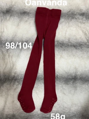 Mörkröda ribbade barnstrumpbyxor - Säljer ett par mörkröda strumpbyxor för barn i storlek 98/104. De är ribbade och har halkskydd under fötterna för extra grepp. Perfekta till höst- och vinteroutfits. 🌸 Oanvända. Storlek 98/104 