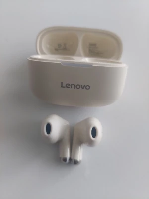 Lenovo vita trådlösa in-ear hörlurar - Snygga vita trådlösa in-ear hörlurar från Lenovo med laddningsetui. Hörlurarna har en stilren och modern design med rundade former och blanka detaljer. Perfekta för musik, poddar och samtal på språng.