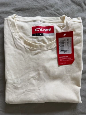 Vit t-shirt från CCM, storlek S - Helt ny, oanvänd vit t-shirt från CCM med diskret logga på bröstet. T-shirten har rund halsringning och korta ärmar. Nypris ca 400kr.