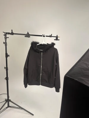 Svart hoodie med fuskpäls på huvan - tuff hoodie, köpte från något instagram märke, var inte som förväntat (100% polyester) köpte för 700kr säljer för 200kr oanvänd