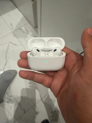 Trådlösa vita in-ear hörlurar - Säljer ett par trådlösa vita in-ear hörlurar med laddningsetui. Hörlurarna har en stilren och kompakt design med silikonproppar och ett smidigt fodral som laddar lurarna när de inte används. Perfekta för musik, poddar och samtal på språng.