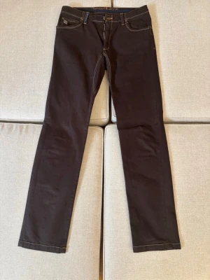 Svarta jeans från Hansen & Jacob - Snygga svarta jeans från Hansen & Jacob med raka ben och kontrastsömmar. Klassisk femficksmodell med dragkedja och knapp i midjan. Perfekta till en avslappnad stil och passar till det mesta. Materialet känns mjukt och följsamt.