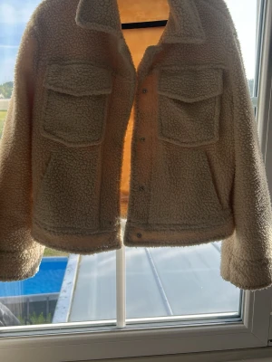 Teddy jacka  - Beiga jacka från ginatricot i storlek 34 med fickor 