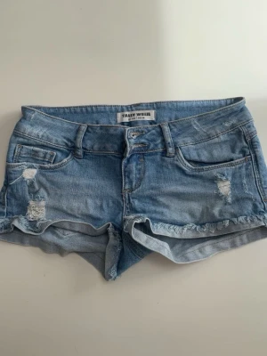 Blå jeansshorts från Tally Weijl - Snygga lågmidjade ljusblå jeansshorts från Tally Weijl med slitna detaljer och fransig kant. Stolek 34. Pria kan diskuteras💞💞