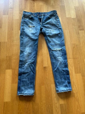 Dondup ripped jeans  - Ljusgråa slim jeans med slitningar från märket Dondup. Jeansen har riktigt snygga slitningar. Midjan är storleken 30 och längden passar dig som är runt 170-175. Priset är ej hugget i sten!
