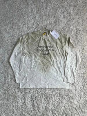 Acne Studios Longsleeve M - Tja! Säljer nu denna riktigt snygga Acne Studios Longsleeve t-shirten. Helt oanvänd. Den är i storlek S men sitter oversized och passar en M. Den är gjord av 100 % bomull och är i riktigt fin kvalitet. Hör av dig om du undrar något! 