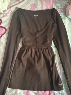 Brun babydoll Hollister - En bruk babydoll långärmad ifrån Hollister i storlek M, men går att knyta där bak (passar mig som är S-Xs). Defekter: vanliga tecken på användning, noppirg/urtvättad, skicket syns på bilderna!❣️ Skicka gärna prisförslag det är inte ett satt pris!❣️