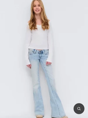 Ljusblå bootcut jeans med broderi - Säljer ett par ljusblå bootcut jeans med snyggt broderade bakfickor. Jeansen har klassisk femficksmodell, normal midja och är tillverkade i denim med lätt tvättad look. Perfekta för en avslappnad och trendig stil.