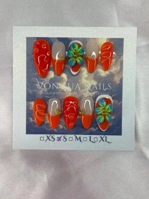 Tangerine 🍊(S);Medium Almond - Snygga handgjorda press-on naglar i medium lång mandelform med stark orange färg, vita detaljer och handgjorda 3D-blommor i blått och grönt. Några naglar har gulddetaljer och french för en unik look. Perfekt för dig som vill sticka ut med färgglada och kreativa naglar.S: 15 mm, 11,5 mm, 12 mm, 11 mm, 9 mm 