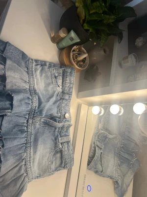 Ljusblå jeanskjol med volang - Supersöt ljusblå jeanskjol med volangkant och klassiska fickor fram. Kjolen har en feminin och avslappnad look med knapp och dragkedja i midjan. Perfekt för dig som gillar denim och vill ha en trendig touch på outfiten. Org pris hos ginatricot 279 så du sparar 79 kr😽😽💓