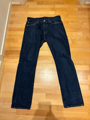 Levis 501 mörkblå - Hej, säljer nu dessa mörkblå Levis 501 jeans i storlek 32/32. Inprincip nyskick och passar mig perfekt som  cirka 1,81 och väger cirka 70kg. Tveka ej på att skicka iväg en fråga och pris ej hugget i sten!