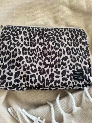 Datorfodral leopardmönster - Säljer ett datorfodral med leopard mönster som aldrig har kommit till användning. I storlek 37 cm I längd 27 cm i bredd och 2 cm i djup. 