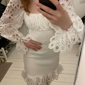 Vit klänning - Vit klänning med spetsarmar. Aldrig använd. Från Pretty little things.