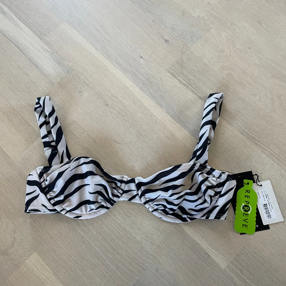 Säljer denna otroligt fina bikiniöverdel från nakd i zebramönster. Aldrig använd, prislapp kvar då den är lite för liten för mig. Storlek 70B vilket är som en XS. . Övrigt.