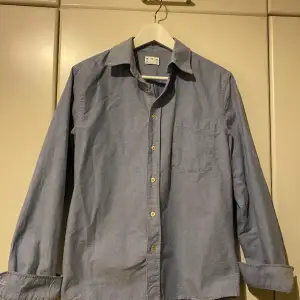 En Ljusblå skjorta från asket som är i gott skick och knappt använd.