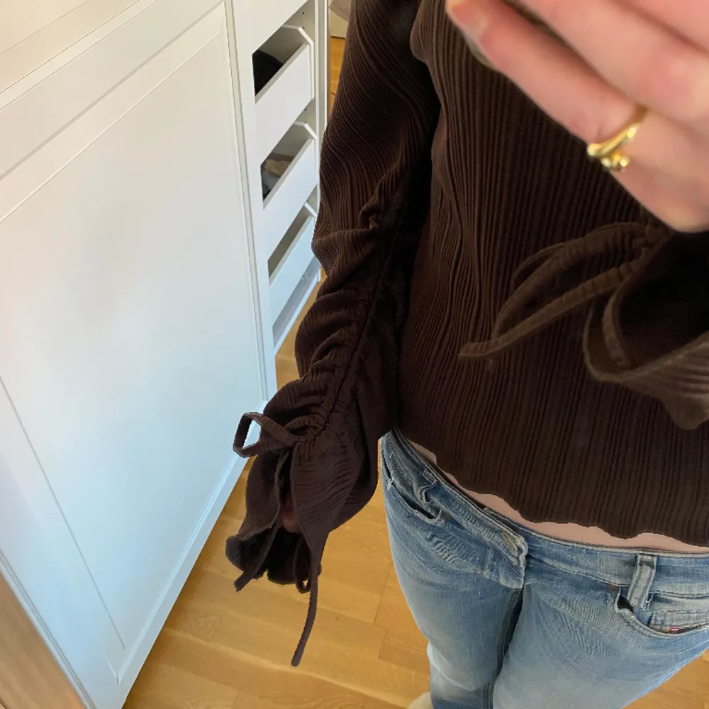 Säljer denna jätte fina bruna blus från Gina tricot. Den har detaljer i båda armarna och är i ett veckat material. Tröjan är i väldigt bra skick och är storlek xxs men känns som en xs eller s🩷. Blusar.