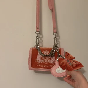 Juicy couture väska i nyskick! - Söt rosa och korallfärgad liten justerbar juicyväska, är helt ny och har endast blivit använd några få gånger så är i nyskick. Skriv för mer bilder eller info eller diskutera pris.❤️