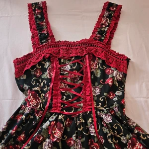  Bodyline klänning vinröd  - Bodyline klänning med rosor. Två rosetter där uppe borta. S. M. Som en saga. Använde en sommar. Dragkedja på sidan. Secret garden. 150kr. Ej frakt. Möts i gbg. St 34 typ. Trång st 38. Jag är 168cm 