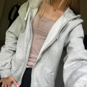 Grå hoodie - Mysig grå hoodie med dragkedja. Passar så fint till allt och sitte jätteskönt. Använd 1 gång, från hm i storlek s. Den sitter perfekt och har en jättefin passform.
