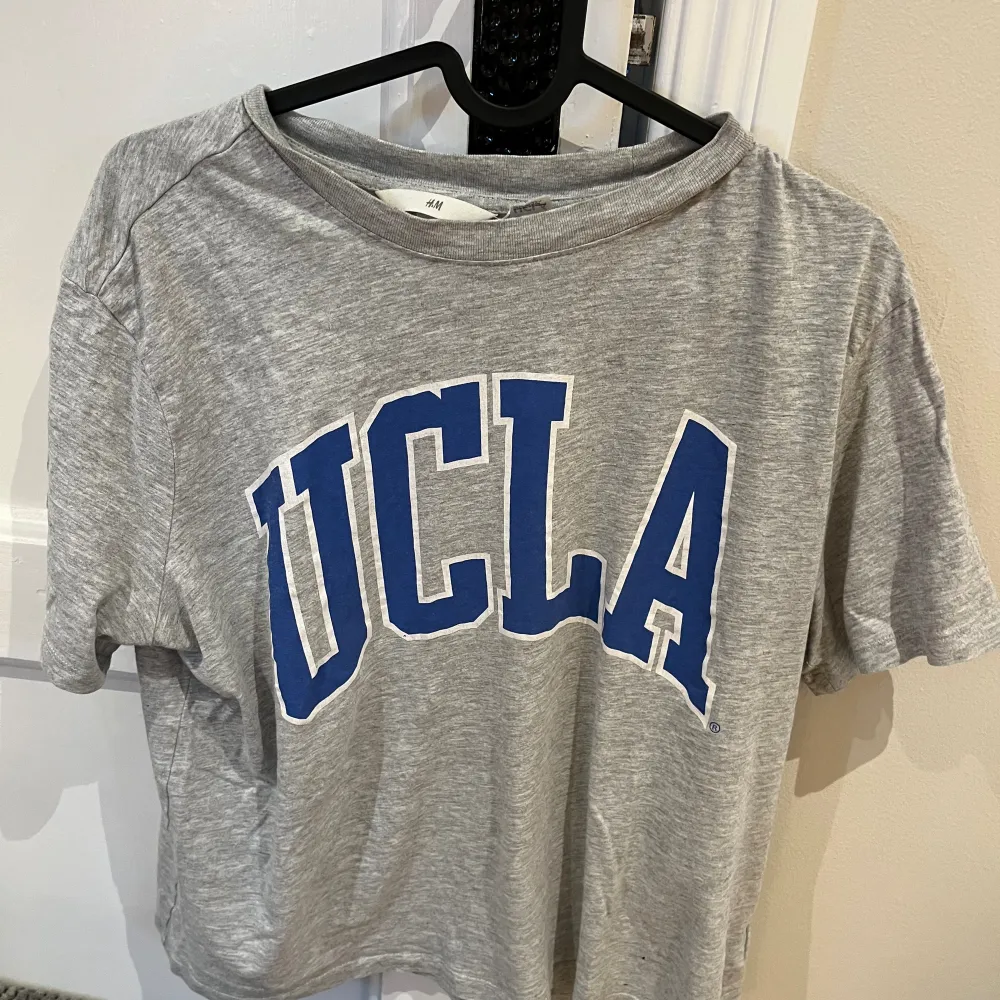 Basic grå T-shirt med ett tryck på där det står UCLA. T-shirts.