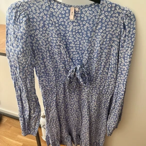 Midsommarklänning  - Blå blommig midsommarklänning med en V - urringning  Storlek 40  Använd 1 gång 