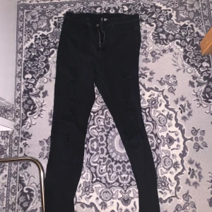 Slitna skinnyjeans - Svarta slitna skinnyjeans från HM Divided. Storlek 42 men sitter som en 40 enligt mig. De är i fint skick!