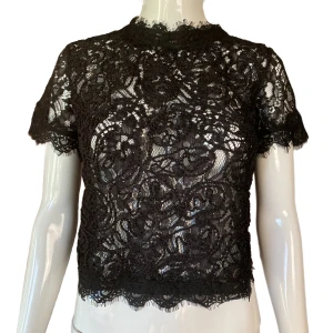 Zara Spetstopp - Black see trough lace from Zara. Eur S. Mannequin uses size XS. Flaw seen in second picture, barely noticeable. Condition 8/10. 100% Polyester Measurements:  Shoulder to shoulder 35cm, Sleeve length 17ish, pit to pit 45cm, length (pit & down) 22cm