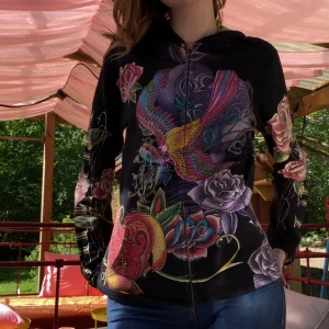 Ed Hardy liknande hoodie - Christian Audigier hoodie i storlek M skick 8/10 inga slitningar men dragkedjan har tappat sitt handtag de går att dra upp och ner utan problem nästan alla stenar sitter kvar saknas ett fåtal inget som syns 