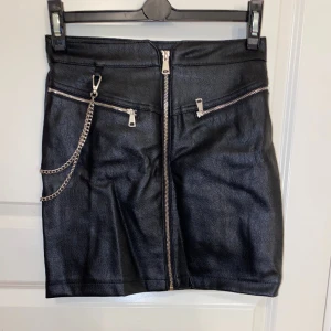 Kjol - Kjol i konstläder med medföljande kedja (kedjan går att ta bort) 