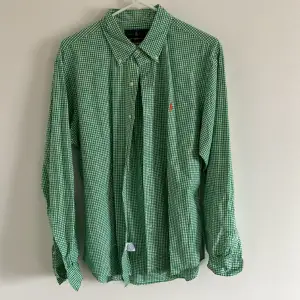 Storlek Large, Slim fit skjorta. Grön och vit rutig skjorta från Ralph Lauren, Säljer då jag ej använder den längre. Nypris är 1 399kr.  Skjortan är i bra skick inga fläckar eller liknande!