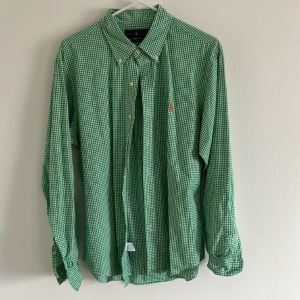Ralph Lauren Skjorta - Storlek Large, Slim fit skjorta. Grön och vit rutig skjorta från Ralph Lauren, Säljer då jag ej använder den längre. Nypris är 1 399kr.  Skjortan är i bra skick inga fläckar eller liknande!