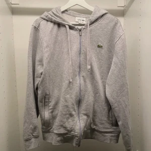 Lacoste zip hoodie - Lacoste zip hoodie i helt okej skick. Står XL i den men skulle säga mer åt M/L hållet. Skick 7,5/10. Priset går att diskutera.