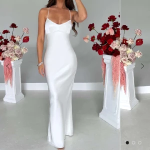 Klänning - Jättefin vit klänning man kan ha till bal, festligare tillfällen osv. Sitter perfekt och den är justerbar eftersom den är knuten i ryggen, jag är 167 cm och den sitter perfekt på mig, även lite lång. Oanvänd 