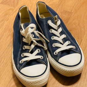Converse All Star låga  - Converse All Star klassisk med lågt skaft. Blå Kanvas. Storlek 36. Nyskick. Pris 600:- Från rökfritt och djurfritt hem. 
