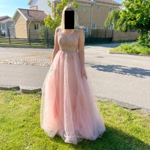 Balklänning  - Balklänning i använt-nyskick. Köpt år 2021 på Helenas Boutique för 3000kr. Användes under någon timme för bal. I färgen rosa med glitter detaljer.