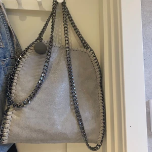 STELLA MCCARTNEY LIKNANDE VÄSKA - En jätte fin väska som är använd 3 gånger max, inga defekter nästan helt ny köptes för 1 månad sen. Säljer pga att den ej kommer till användning. Skriv för fler bilder eller frågor! Diskuterar gärna pris!💗(väskan är alltså inte en riktig stella McCar