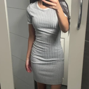 Grå kort tajt klänning - Grå kort tajt tshirt-klänning köpt från H&M. Jättefin men kommer tyvärr inte till användning. Väldigt bra skick då den knappt är använd💗 pris går att sänkas 