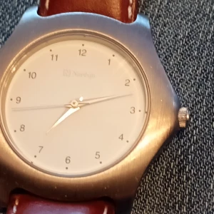 Klocka Nordsjö med läderrem. - Klocka Nordsjö med läderrem silverfärgade. 35 mm.Nytt batteri behövs.