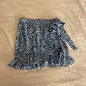 Kjol - Jättesöt blå somrig kjol med blommor och volanger💞storlek S, aldrig använd 